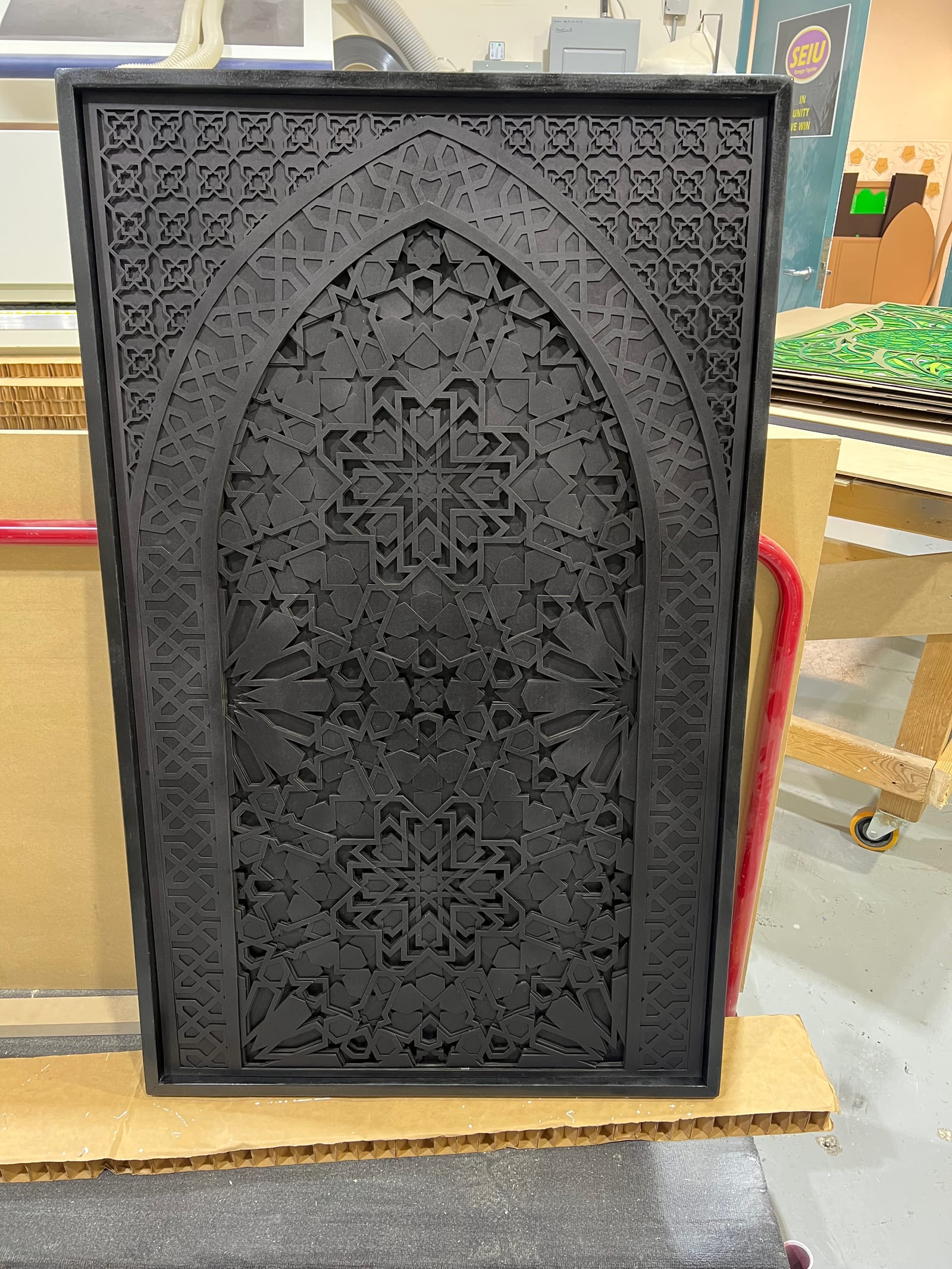 The all-black Moroccan Arch wheeled on a red pallet jack out of the workshop.