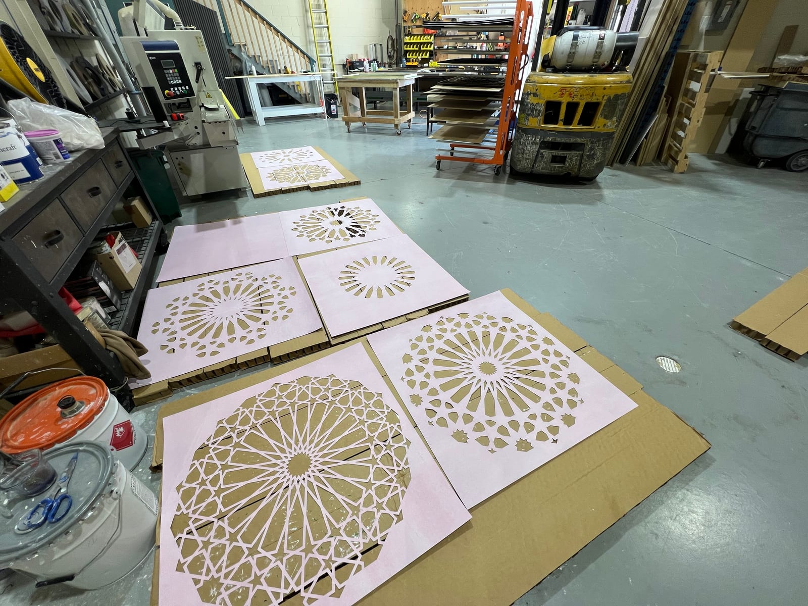 A workshop ceiling lined with small khatem-pattern pieces in progress.