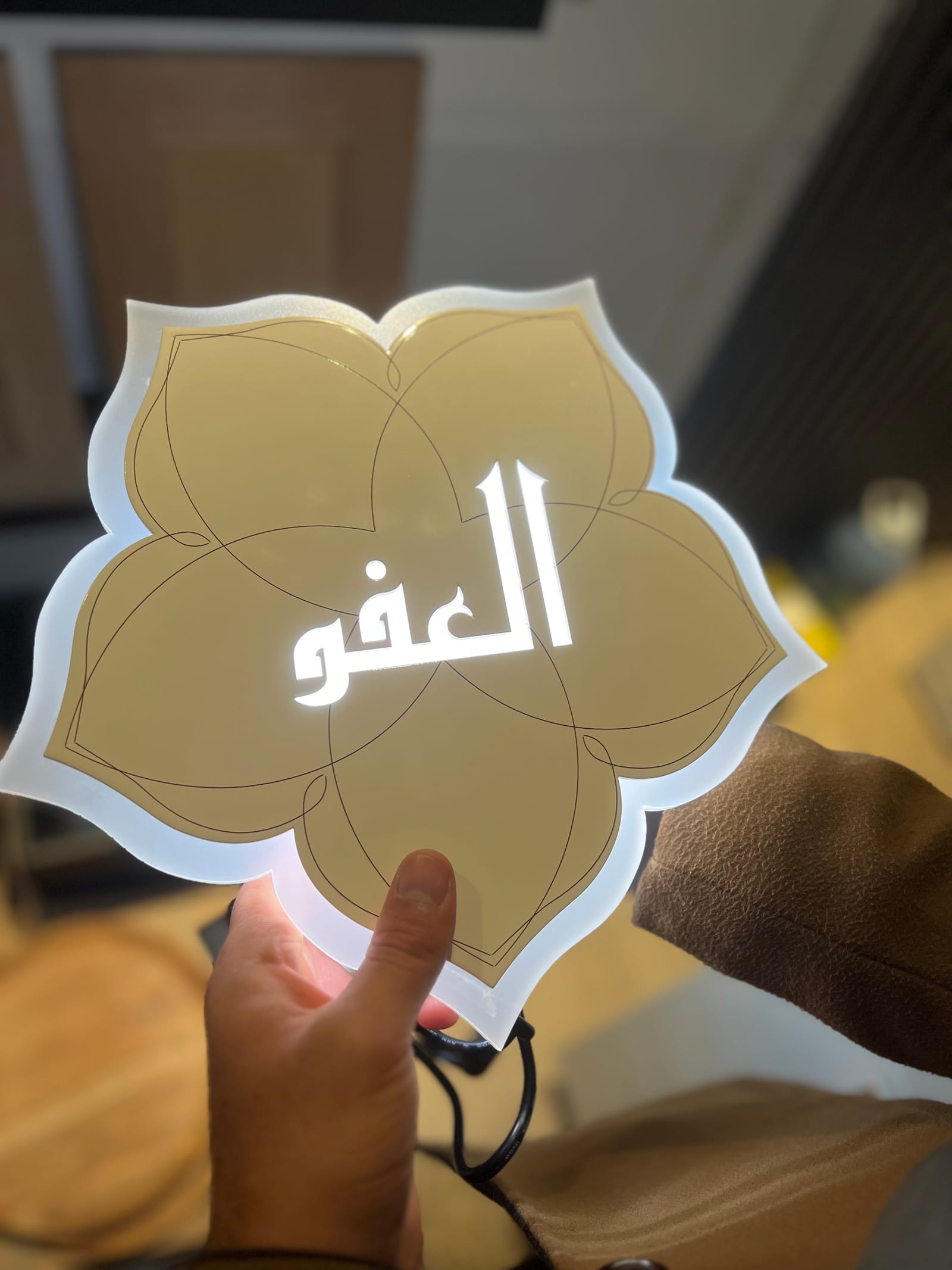 A finished khatem piece in gold with white Arabic calligraphy.